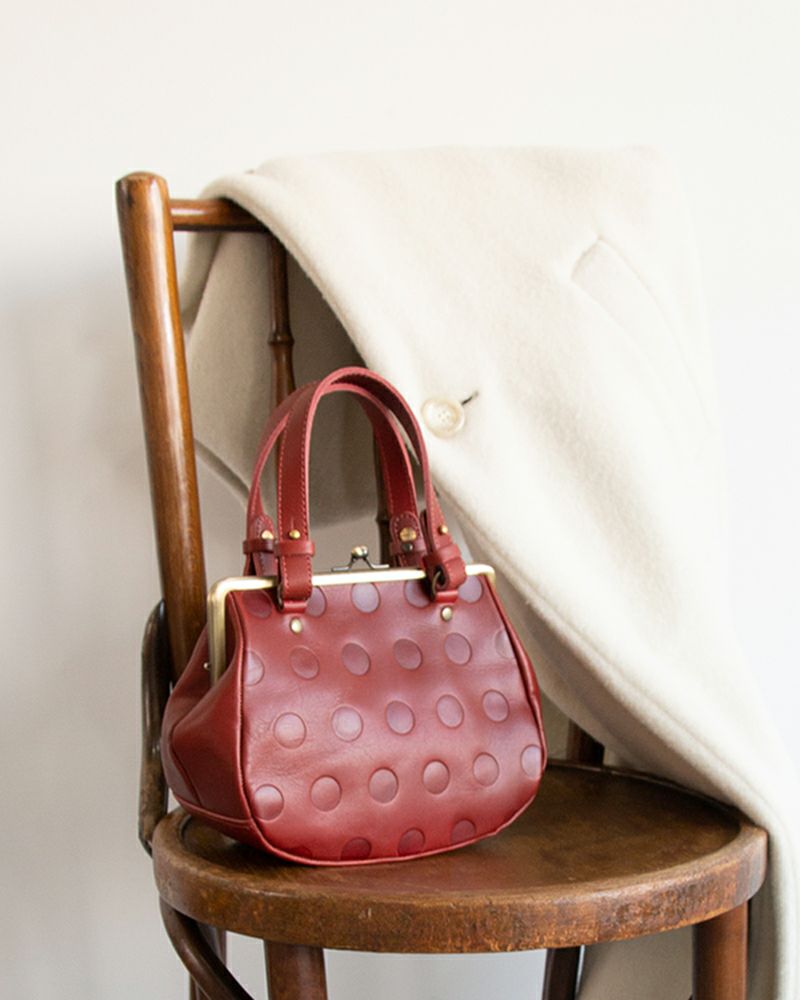 チェリーレッドの革が甘さと大人っぽさを両立。コーデに華やかさを添える一品。