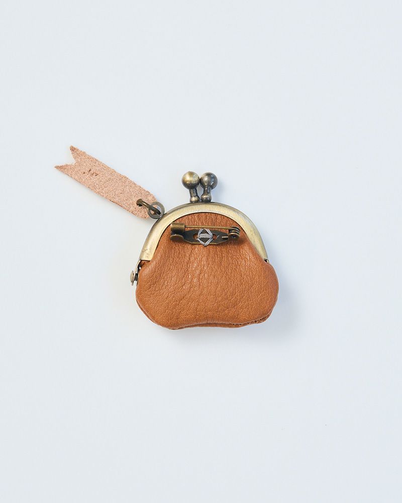 小さな薬やアクセサリーが入る革のがま口ブローチ。日常を彩る“大人のおまもり”アクセです。