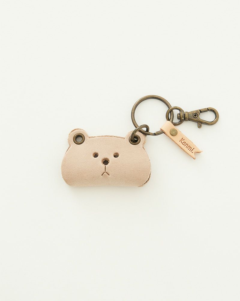 柔らかなニュアンスカラーのクマモチーフが、鍵やポーチに落ち着きを与えるレザーの風合い